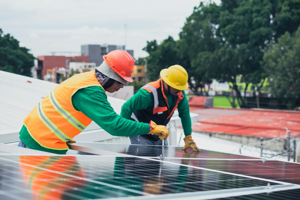 commercial construction crew working on solar panels outdoors on cold, rainy day