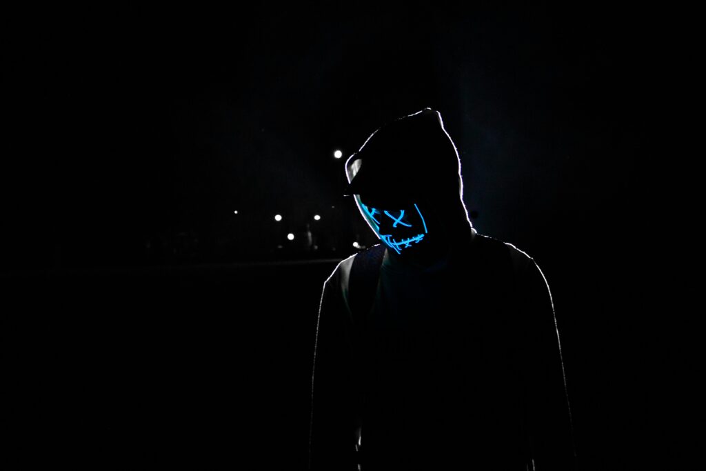 a night-time photograph of an actor depicting a cyber criminal.