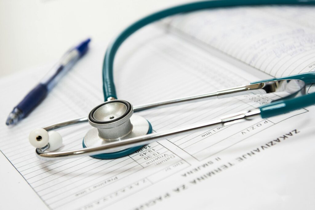 Close-up Photo of a Stethoscope laying on top of patient records