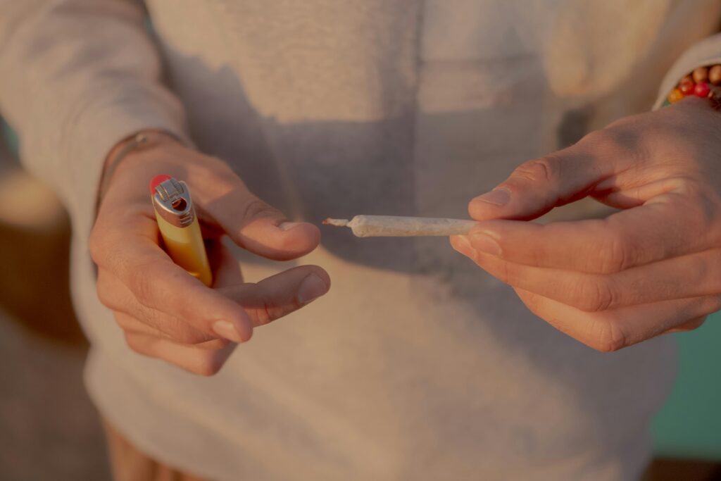 A person holding a cannabis joint about to light it.