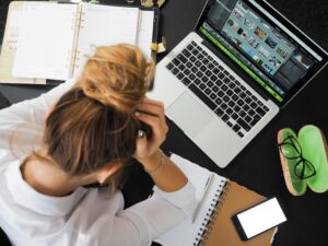 Woman Sitting in Front of Macbook looking at insurance documents